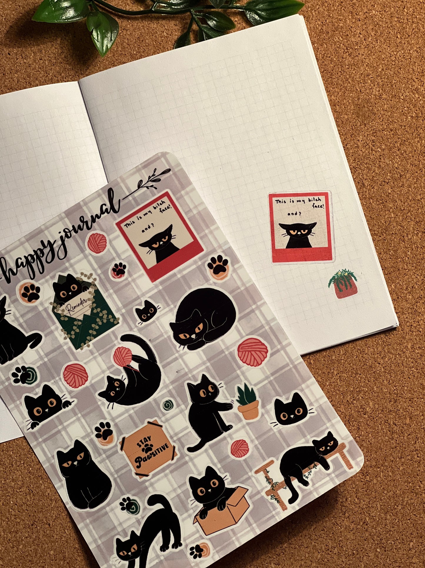 Sheet of cat-themed stickers with a 'happy journal' design on a brown surface.